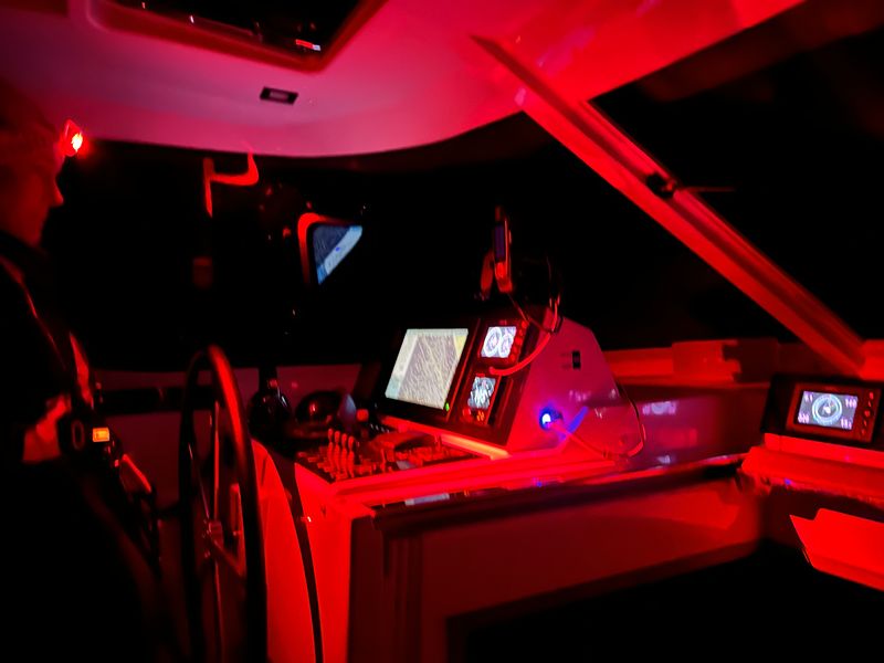 Standing watch at night, monitoring navigation and winds